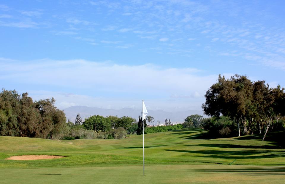 Golf du Soleil : green au drapeau, montagnes au fond