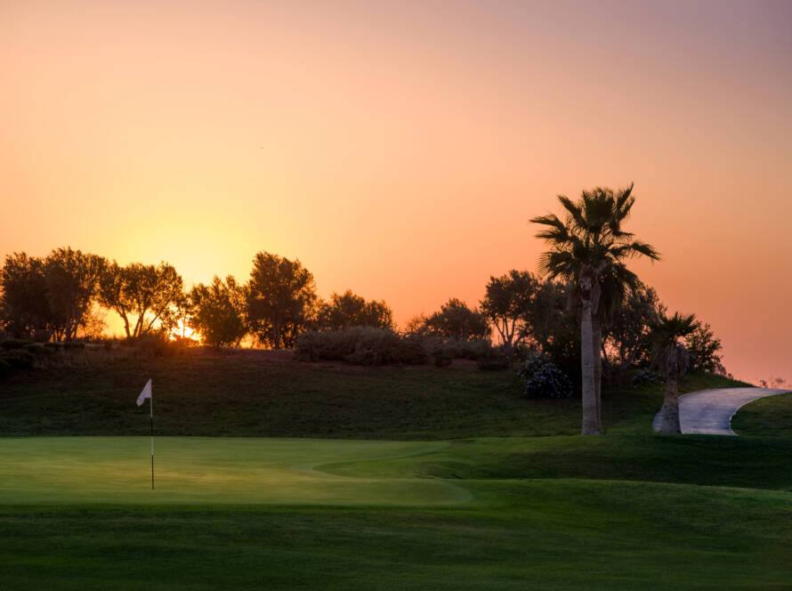 PalmGolf Marrakech Ourika : green au drapeau blanc au couchant