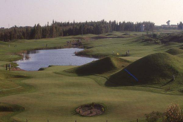 Royal Golf Benslimane : lac, buttes engazonnées, forêt au fond